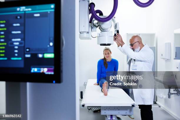 doctor examining and making x-ray of patients foot - medical scanner stock photos et images de collection