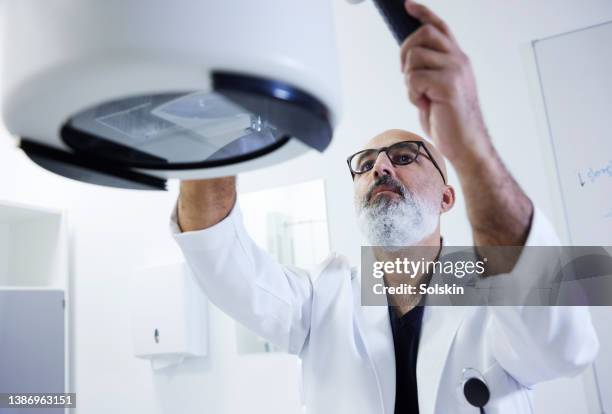 doctor using x-ray equipment - tecnología medica fotografías e imágenes de stock