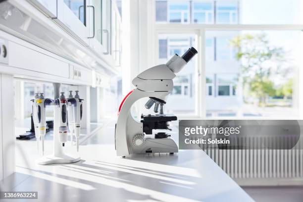 microscope in empty science laboratory - 顕微鏡 ストックフォトと画像