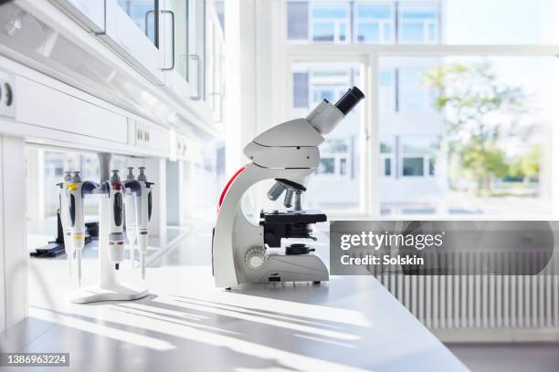 microscope in empty science laboratory - medische artikelen stockfoto's en -beelden
