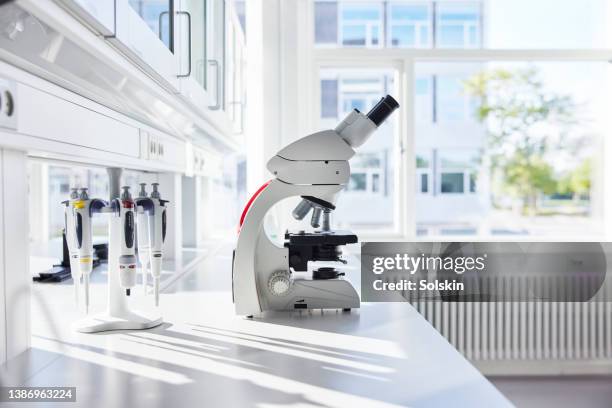 microscope in empty science laboratory - scientific research stock pictures, royalty-free photos & images