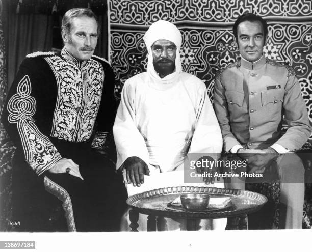 Charlton Heston, Laurence Olivier, and Richard Johnson sitting together in a scene from the film 'Khartoum', 1966.