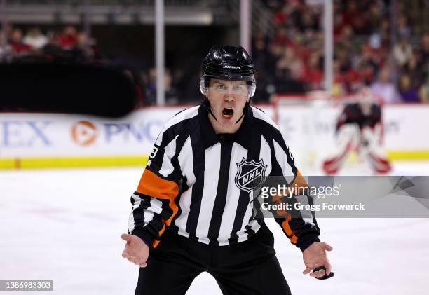 Referee Ian Walsh expresses himself to the bench area during an NHL game between the Carolina Hurricanes and the Washington Capitals during an NHL...