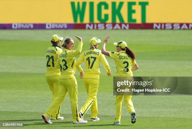 Ashleigh Gardner of Australia celebrates with teammate Megan Schutt after dismissing Laura Wolvaardt of South Africa during the 2022 ICC Women's...