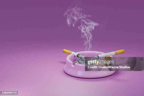 smoking cigarettes left on porcelain ashtray full of ash - cendrier photos et images de collection