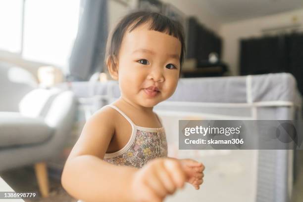 asian baby girl feeling negative emotion be irritable toothache at home - caneca para bebê - fotografias e filmes do acervo