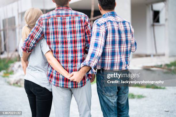 unfaithful woman with construction house in background - affairs stock pictures, royalty-free photos & images