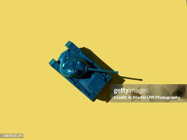 plastic toy tank isolated on yellow background. - storage tank stock pictures, royalty-free photos & images