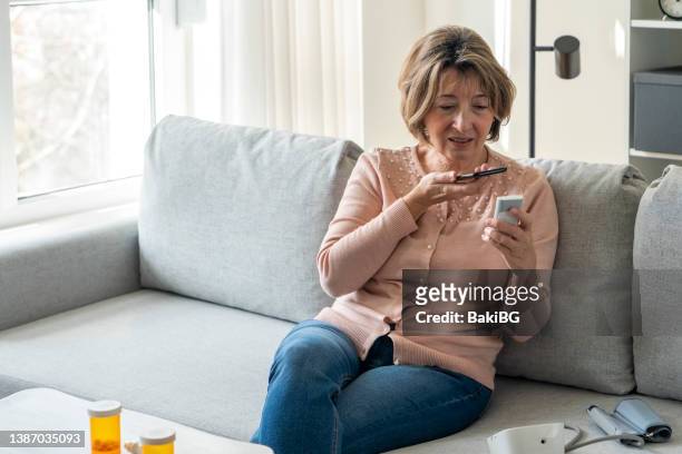 senior woman having an online appointment with doctor from home - diabetes pills stock pictures, royalty-free photos & images
