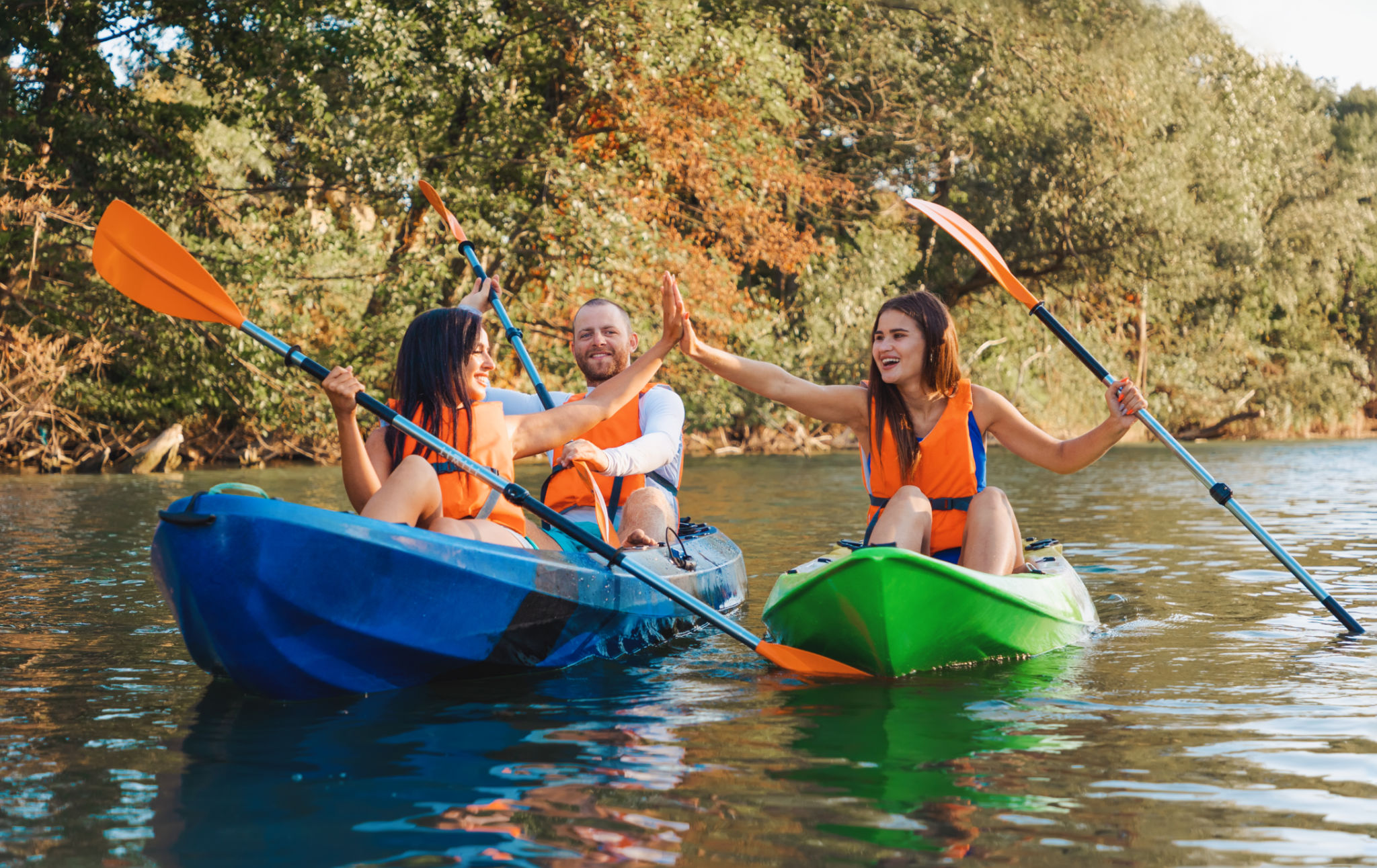 Kayaking at th river. A group of happy friends are high five sitting in kayaks. World Tourism Day concept Kayaking at th river. A group of happy friends are high five sitting in kayaks. World Tourism Day concept