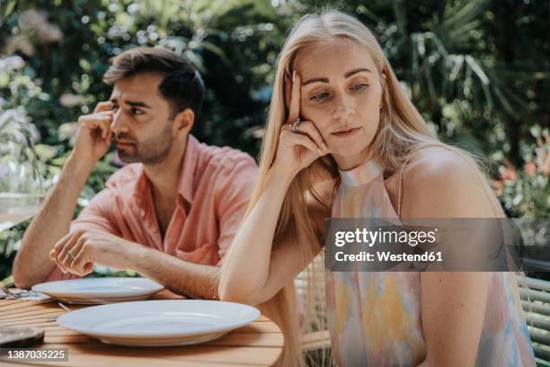 couple ignoring each other at outdoor table - human relationship stock pictures, royalty-free photos & images