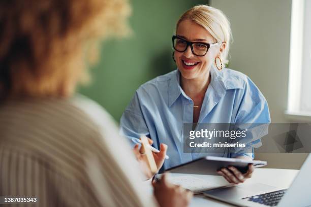 two businesswoman working together on a new project - 2 ladies table computer stock pictures, royalty-free photos & images