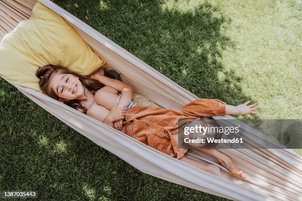 smiling sister and brother lying in hammock at back yard - brother sister stock pictures, royalty-free photos & images