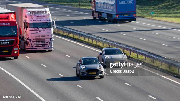 tagesverkehr (ford puma, porsche panamera) auf der autobahn a1 bei rijssen - porsche stock-fotos und bilder