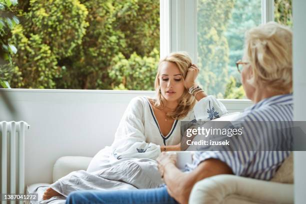 sad daughter discussing with mother at home - mom head in hands stock pictures, royalty-free photos & images