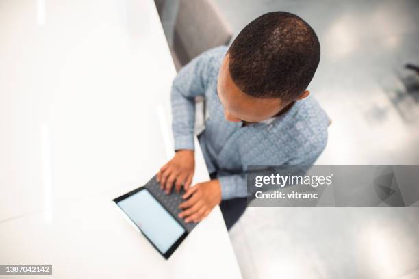 overhead-aufnahme eines mannes, der zu hause am laptop arbeitet - raised finger stock-fotos und bilder