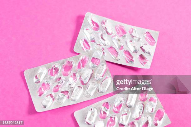 empty pill wrappers on a pink table. - falta imagens e fotografias de stock