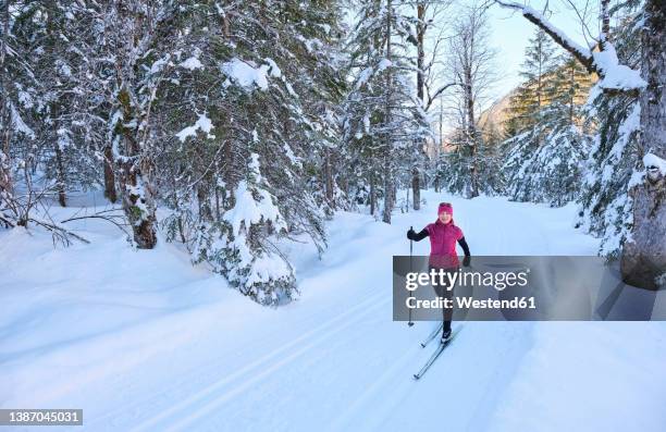 senior woman with ski pole skiing in snow on vacation - ski pole stock-fotos und bilder