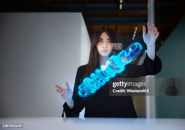 female engineer analyzing shock absorber in mid-air at office - holograma fotografías e imágenes de stock