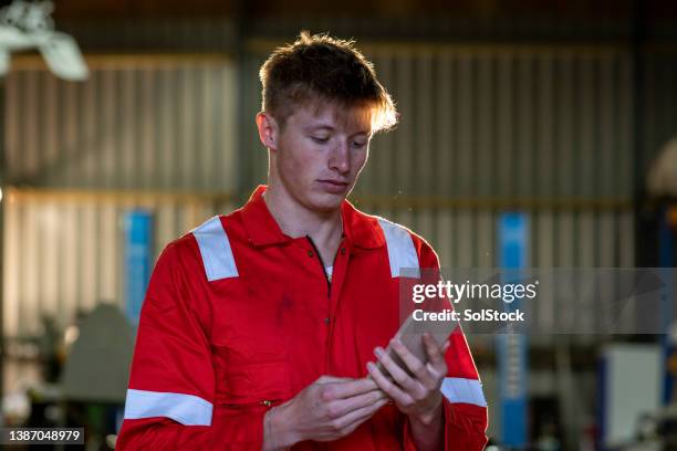 mechanic using his phone his break - overall stockfoto's en -beelden