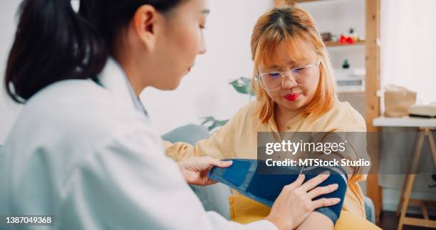 médico asiático que le mide la presión arterial con el paciente en casa. primer plano. - arteria fotografías e imágenes de stock