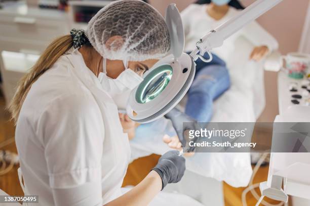kosmetikerin arbeitet im nagelstudio - podiatrist stock-fotos und bilder