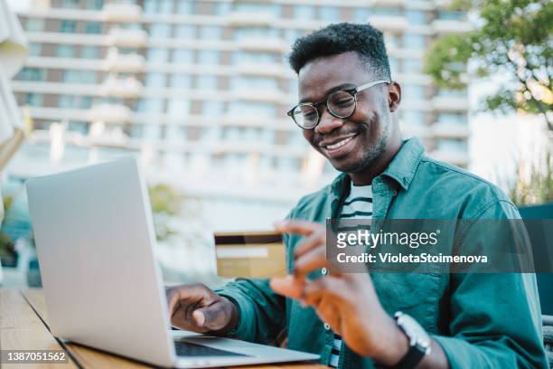 man using laptop and credit card for online shopping in city cafe. - business man sitting banking imagens e fotografias de stock