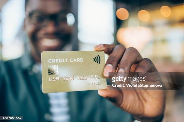 man holding a credit card. - credit card bildbanksfoton och bilder