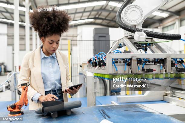 businesswoman holding tablet pc working in factory - factory engineer woman stock pictures, royalty-free photos & images