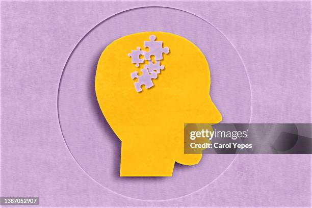 paper head with puzzle pieces-autism concept.purple paper work background - brain food photos et images de collection