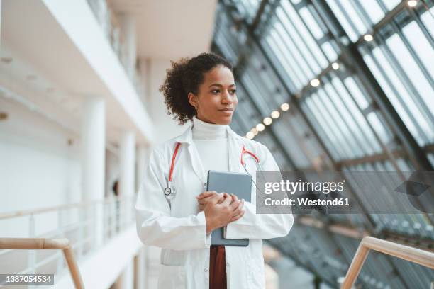 thoughtful doctor with tablet pc in medical clinic - fotografia de três quartos imagens e fotografias de stock