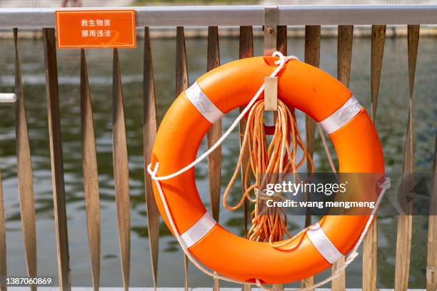 a life buoy on a railing by the river - nödraket bildbanksfoton och bilder