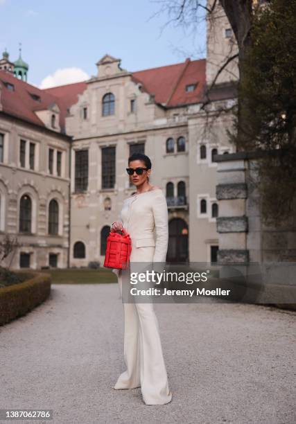 Füsun Lindner seen wearing a black Celine sunglasses, gold earrings from Louis Vuitton, a creme off-shoulder top from Salvatore Ferragamo, matching...
