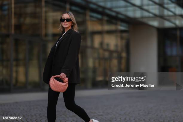 Luisa Maier seen wearing a black Prada sunglasses, gold necklace and gold earrings from Glambou, a white shirt from Aym, a black oversized blazer...