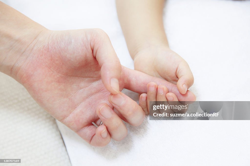 Daughter holding Mother's finger