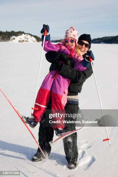 mother hugging daughter on ski slope - cross country ski stock pictures, royalty-free photos & images