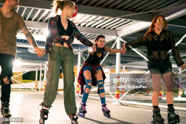 group of happy friends rollerblading together in a parking lot - inline skate 個照片及圖片檔