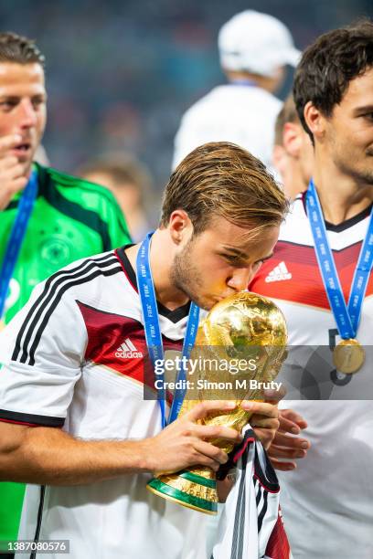 Mario Goetze of Germany and goal scorer kisses the World Cup trophy with teammates. World Cup Final match between Germany and Argentina at the...