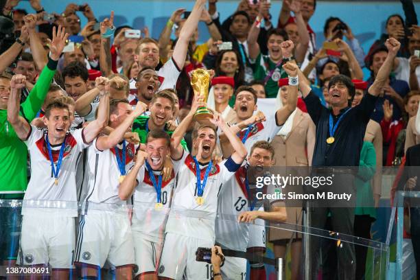 Philipp Lahm captain of Germany raises the World Cup trophy with teammates, Thomas Mueller, Metzul Oezil, Lucas Podolski, Kevin Grobkreutz, Miroslav...