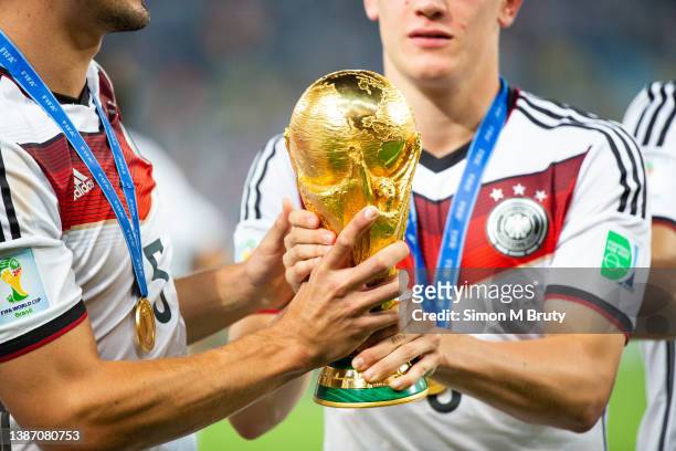 The World Cup Trophy is passed around as the German team celebrates their victory. World Cup Final match between Germany and Argentina at the...