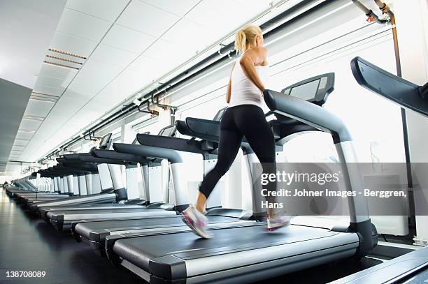 woman exercising on treadmill in gym - treadmill stock pictures, royalty-free photos & images