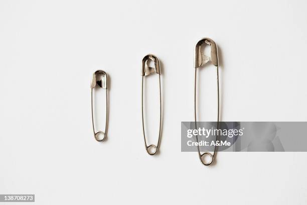 three safety pin in a row, studio shot - safety pin stock pictures, royalty-free photos & images