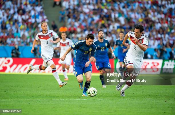 Lionel Messi of Argentina and Mats Hummels and Benedikt Hoewedes of Germany during the World Cup Final match between Germany and Argentina at the...