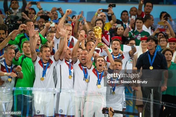 Philipp Lahm captain of Germany raises the World Cup trophy with teammates, Thomas Mueller, Metzul Oezil, Lucas Podolski, Kevin Grobkreutz, Miroslav...