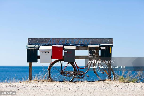 letterboxes and bicycle with sea in background - oland stock-fotos und bilder