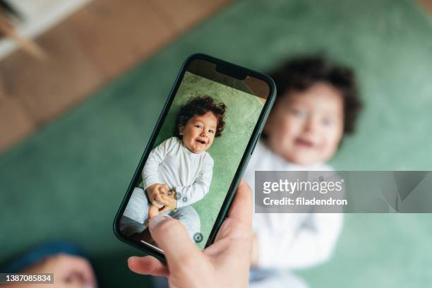 madre toma foto de su bebé - photo messaging fotografías e imágenes de stock