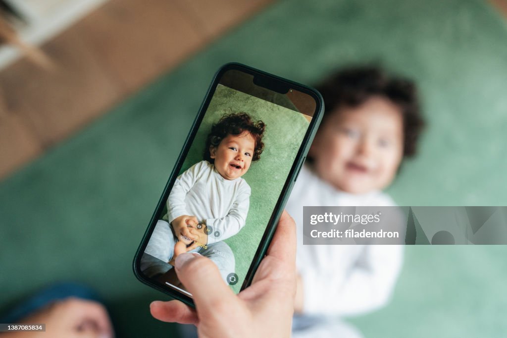 Mother taking photo of her baby