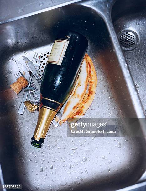 champagne bottle and cutlery in sink, close-up - the morning after stock pictures, royalty-free photos & images