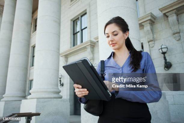caucasian businesswoman using digital tablet outdoors - regierung stock-fotos und bilder