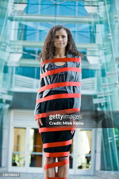 caucasian businesswoman standing wrapped in red tape - bureaucracy stock pictures, royalty-free photos & images